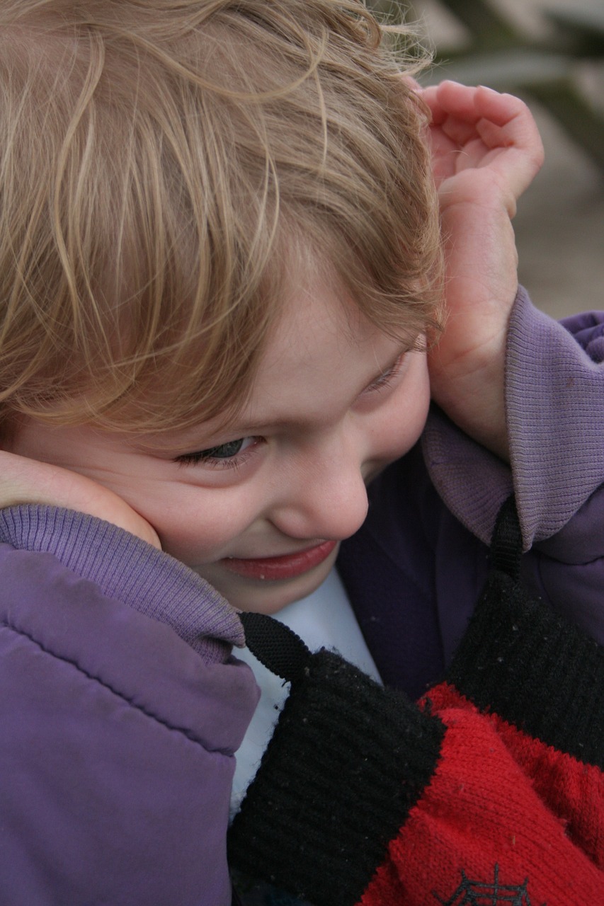 Child with hands pressed to the sides of its head